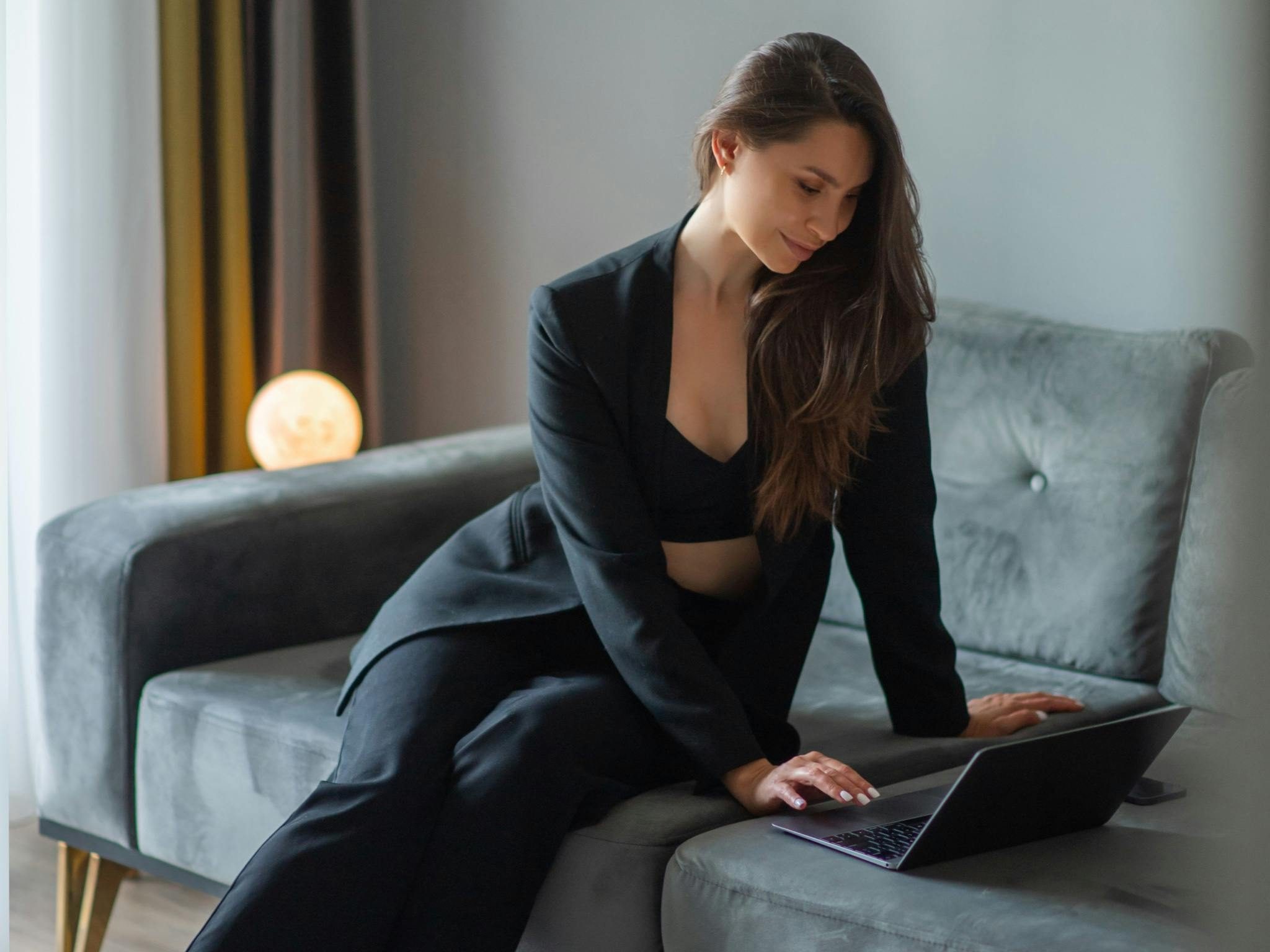 Businesswoman in suit working remotely on a laptop at home in Chicago.